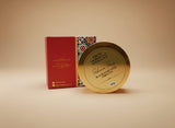 Gold soap bar with decorative packaging on a floral tablecloth Gold soap bar with decorative packaging on a floral tablecloth