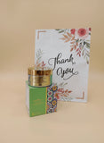 Cosmetic jar with gold lid and colorful packaging on a floral-patterned background Cosmetic jar with gold lid and colorful packaging on a floral-patterned background
