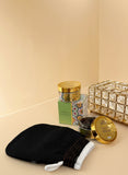 Gold containers, black bag, and decorative items on a surface with a blurred background Gold containers, black bag, and decorative items on a surface with a blurred background