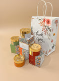 Gift set with jars and a floral-patterned bag on a beige background Gift set with jars and a floral-patterned bag on a beige background