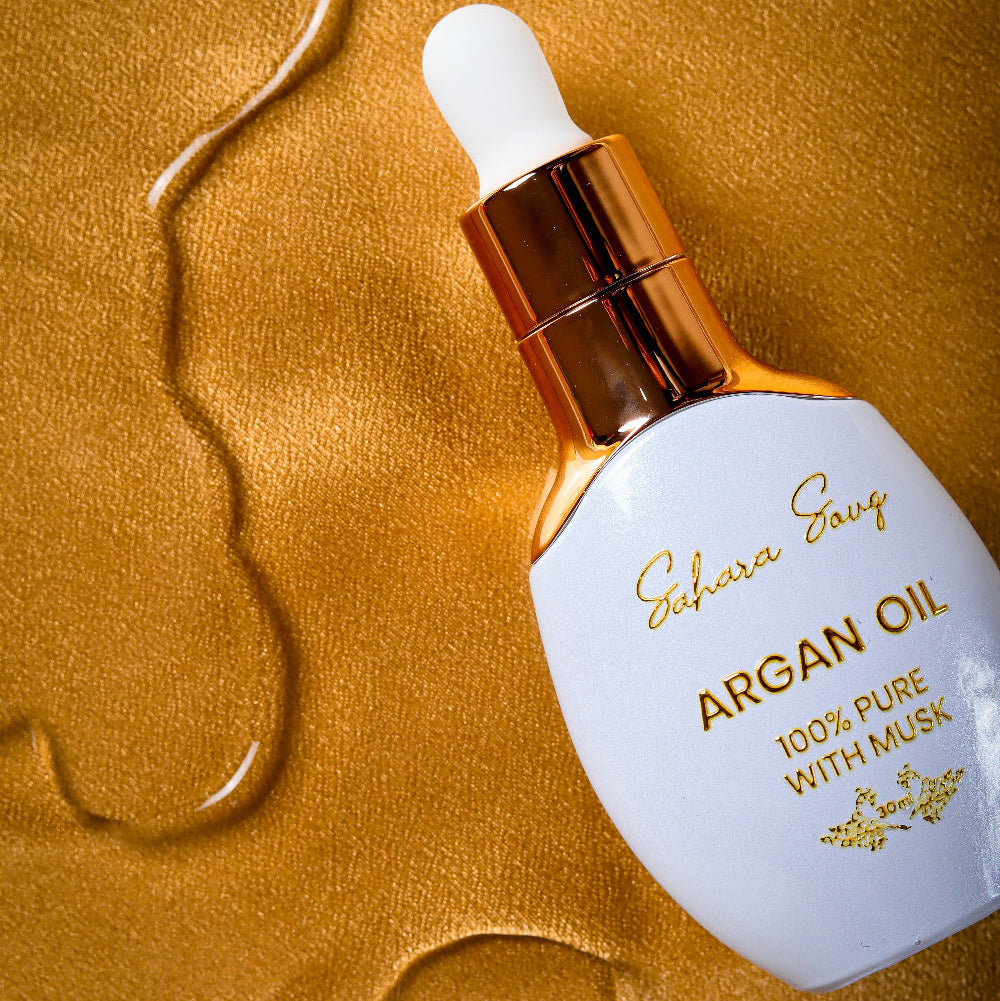 IMAGE OF WHITE DROPPER OF ARGAN OIL WITH GOLD STICKER AND LID IN GOLDEN VLOTH