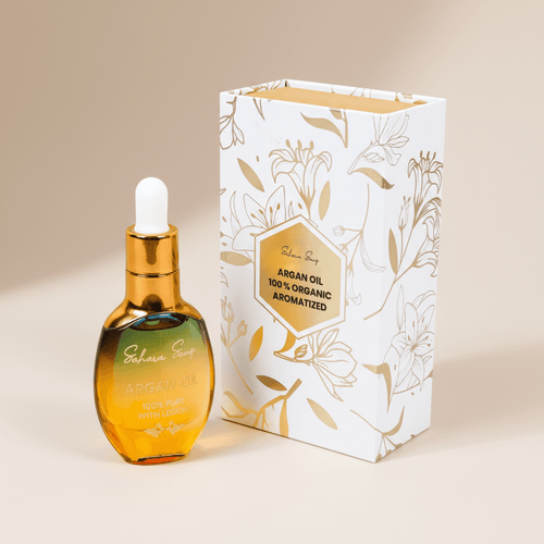 Lemon argan brightening face oil bottle beside its white and gold gift box
