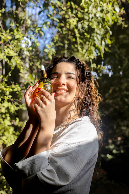Woman holding a bottle of oil with a forest background