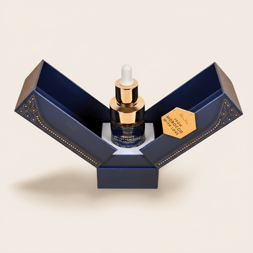 Pure argan oil dropper bottle in an open navy and gold gift box