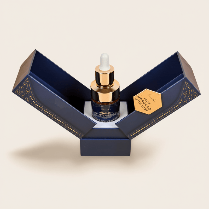 Pure argan oil dropper bottle in an open navy and gold gift box